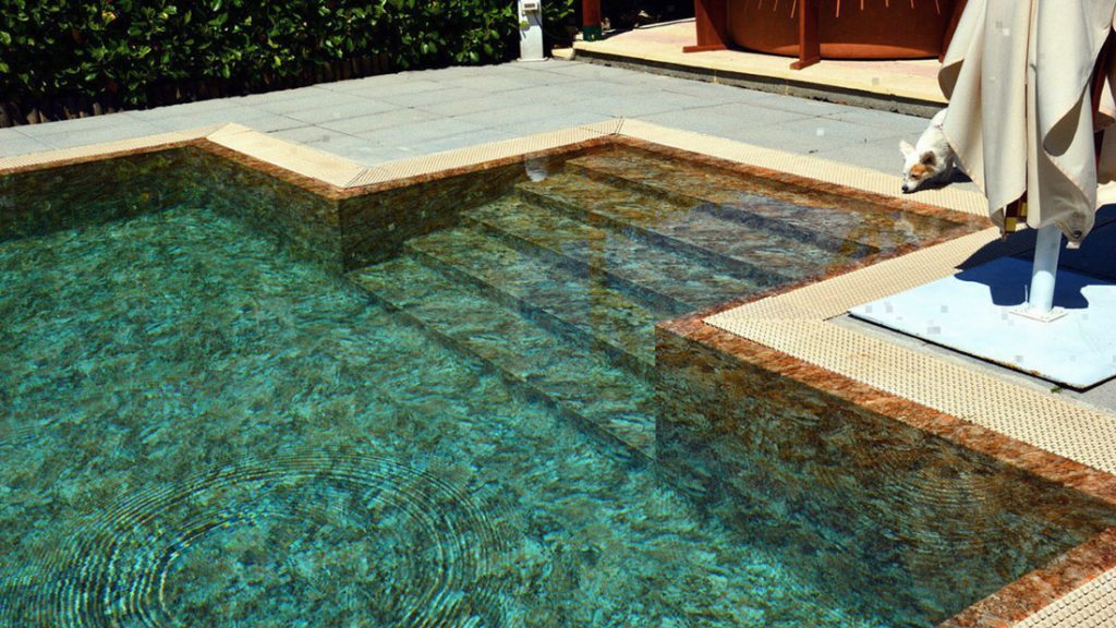 Sfeerbeeld van een rechthoekig buitenzwembad met instapnis, afgewerkt met folie Alkorplan Touch textuur "Authentic".
