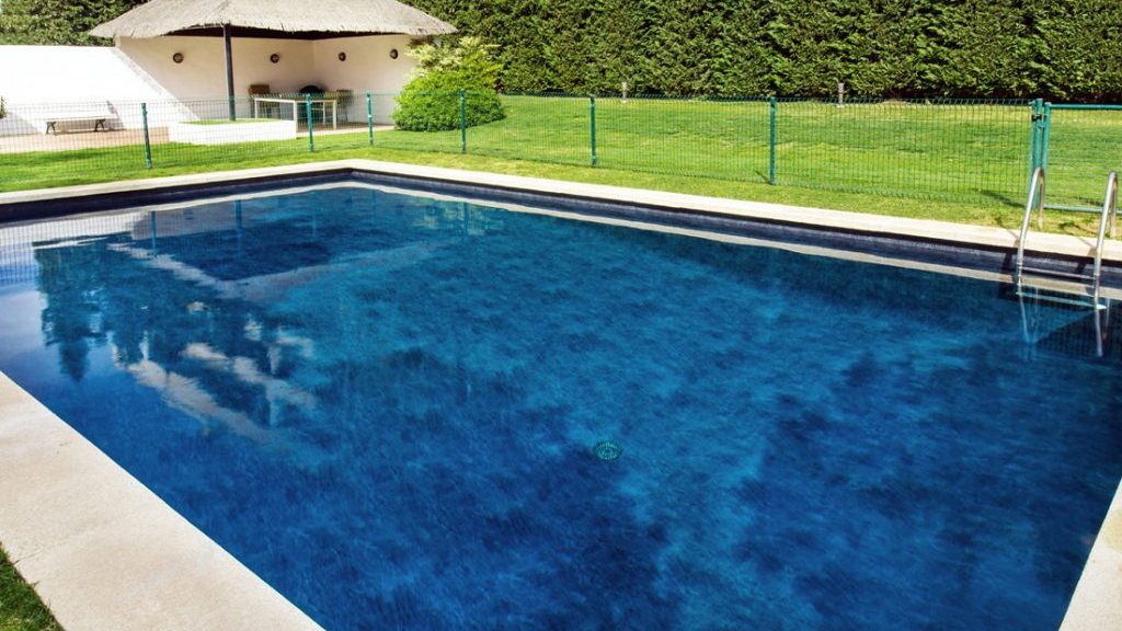 Sfeerbeeld van een rechthoekig buitenzwembad met trap, afgewerkt met folie Alkorplan Touch textuur "Elegance"