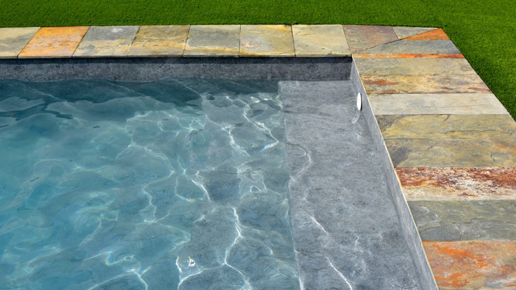 Sfeerbeeld van een buitenzwembad met stenen boord, afgewerkt met folie Alkorplan Touch textuur "Prestige"